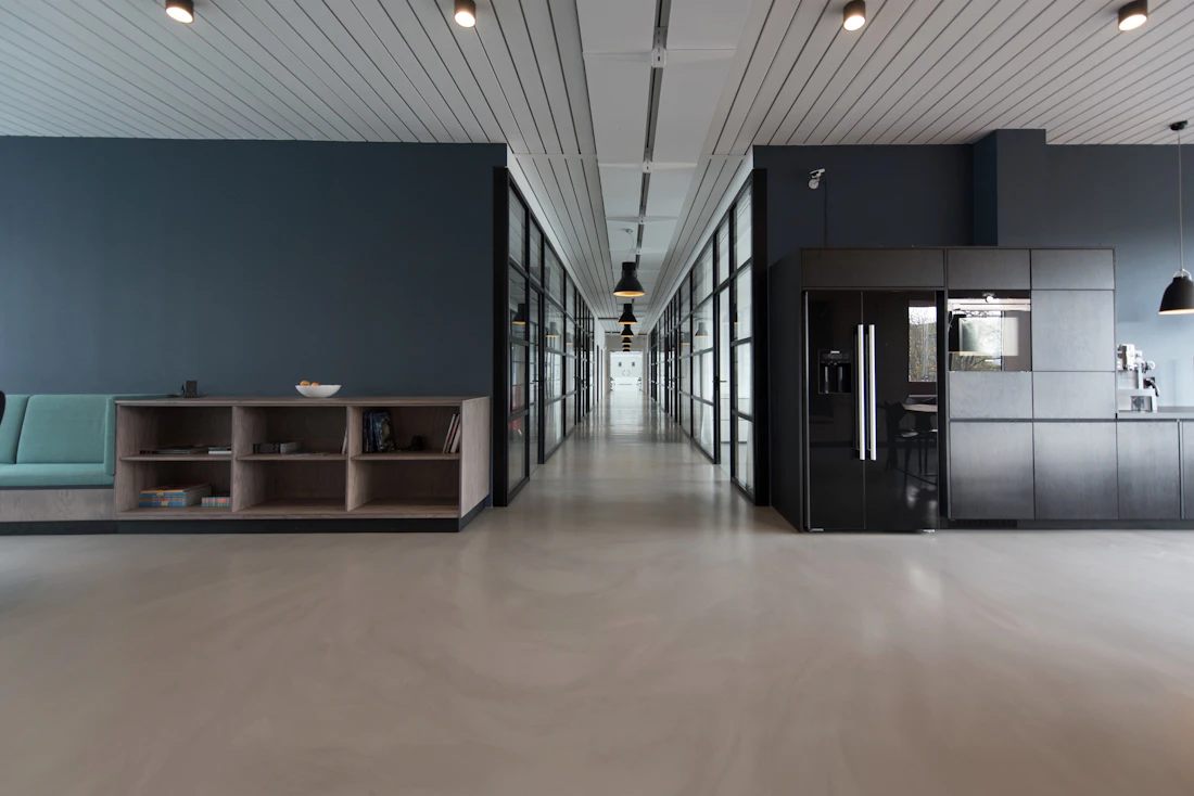 Sala de trabalho ampla com mesas e iluminação neutra